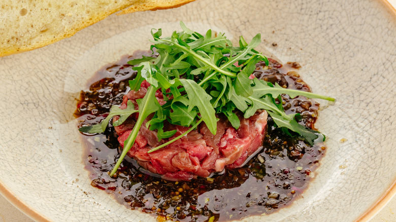 A plate of beef tartare with fresh garnish