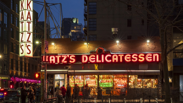 Nighttime view of tourists waiting to enter the iconic Katz's Delicatessen.