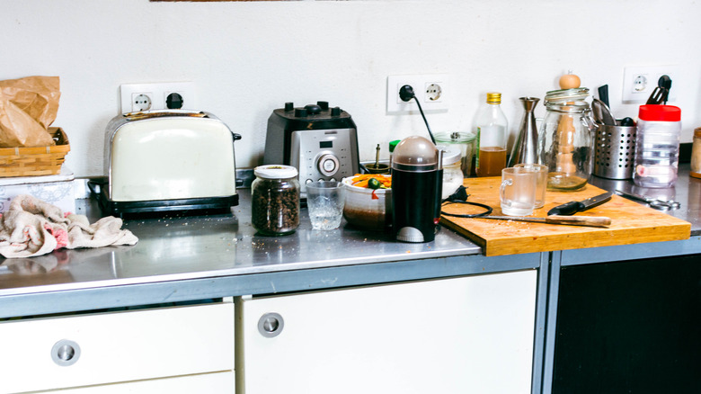 Disorganized kitchen counter holding a blender base, toaster, and other kitchen gadgets
