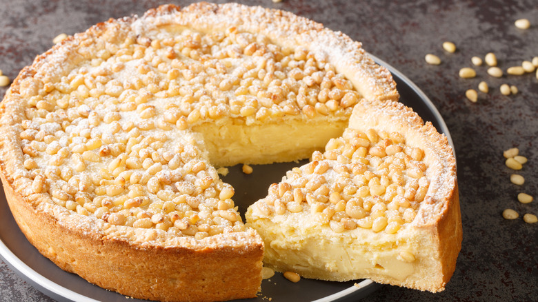Italian torta dessert topped with nuts and powdered sugar