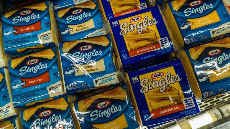 Packages of Kraft Singles in refrigerator case at supermarket