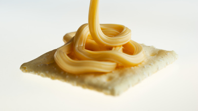 Spray cheese piled on cracker