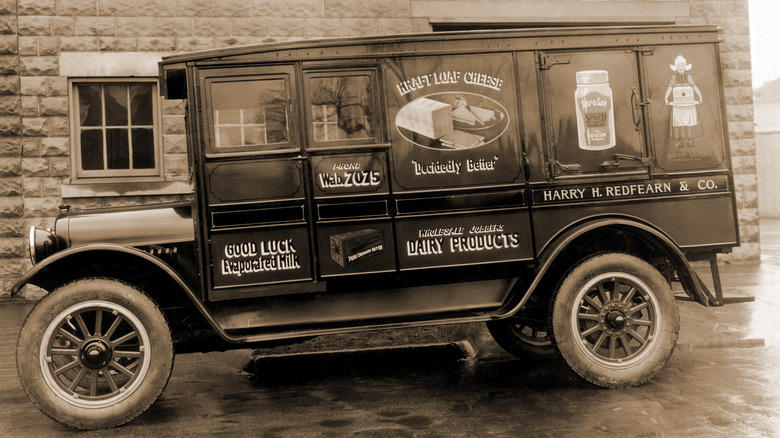 Early version of a refrigerated truck with slogans on the side including one for Kraft loaf cheese