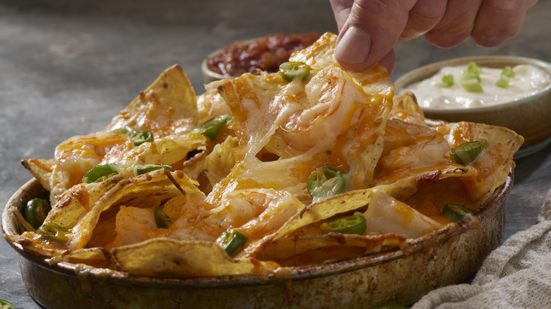 Plate of nachos with salsa and sour cream