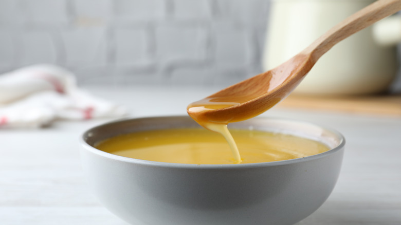 wooden spoon pouring clarified butter into bowl