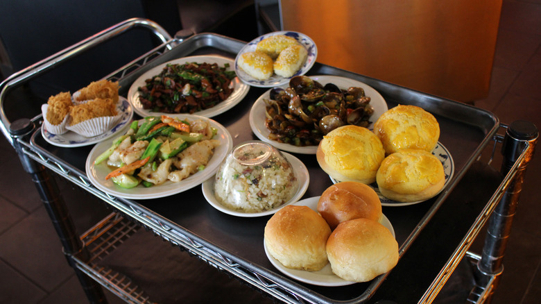 A dim sum cart loaded with dishes of food.