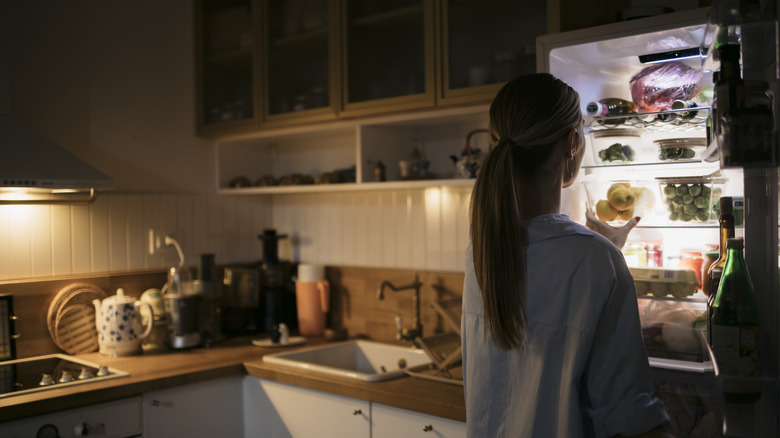 Woman opening fridge