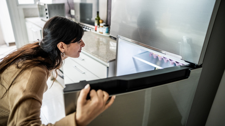 Woman looking inside a refrigerator