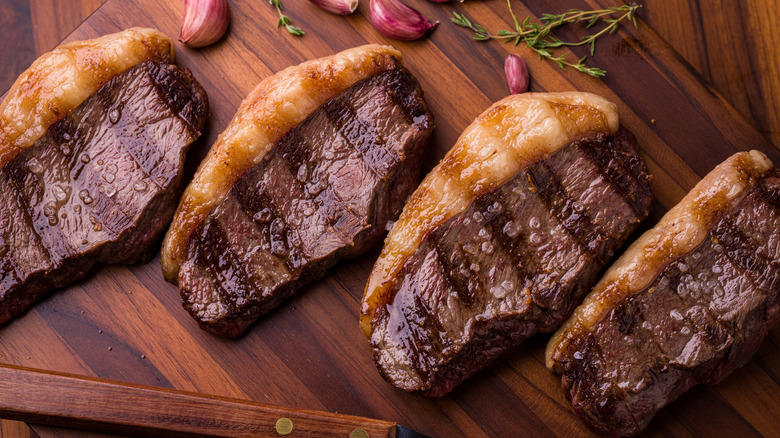 Grilled picanha steaks on a wooden cutting board
