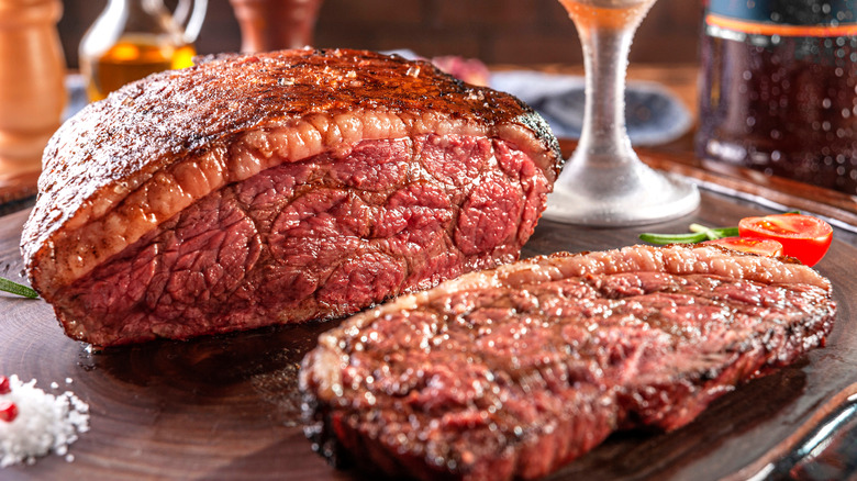 A picanha steak with a slice cut out off on a table