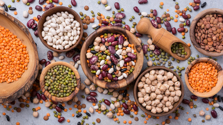 different types of dried beans in wooden bowls