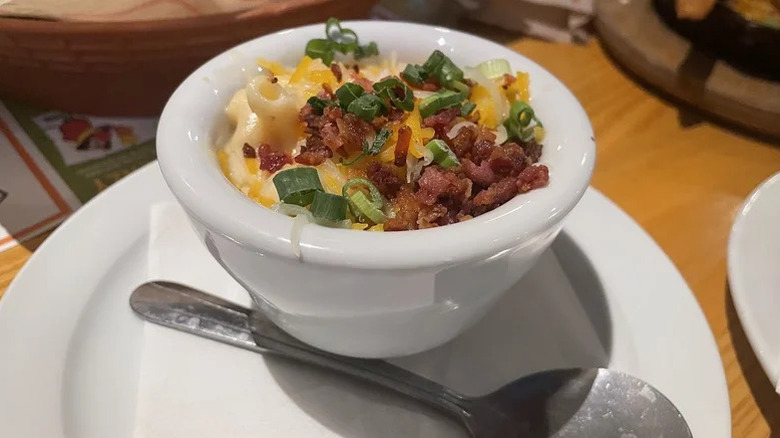 Chili's loaded white cheddar mac and cheese with extra cheese, bacon, and green onions served inside a white bowl