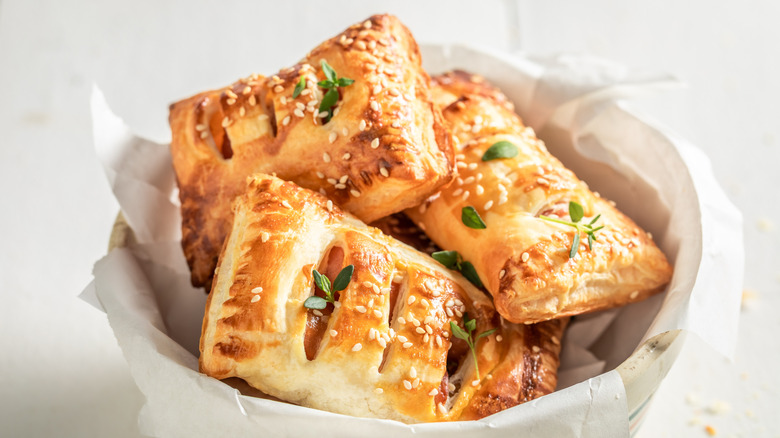 Golden pastries made with puff pastry in a bowl.
