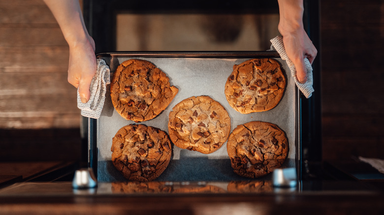 Cookies on a baking sheet being taken out of the oven