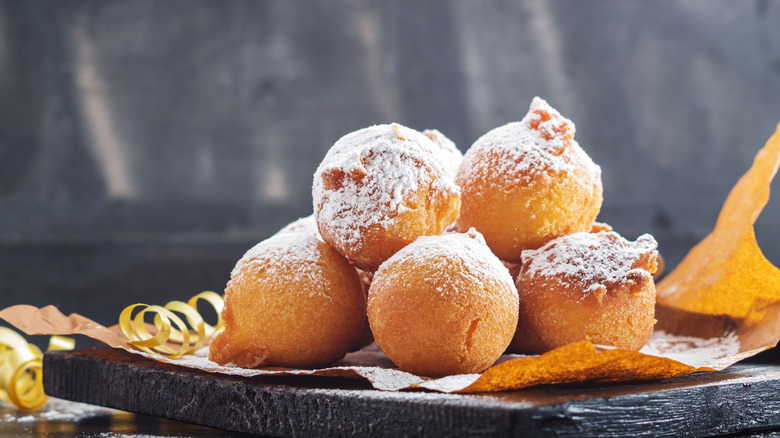 Zeppoles covered in sugar on a plate