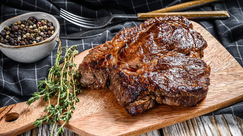 Grilled chuck eye roll steak on a chopping board