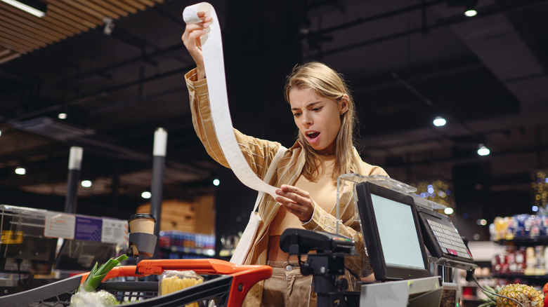 Shopper examining a long grocery store bill