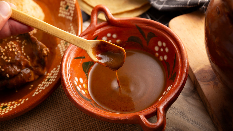 mole poblano in a bowl with a spoon pulling some out
