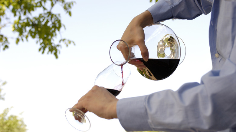 Pouring wine from a decanter into a stem glass