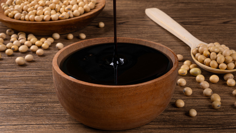 Thick soy sauce being drizzled into a bowl.