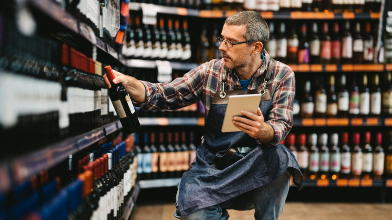 Salesman checks bottles of alcohol