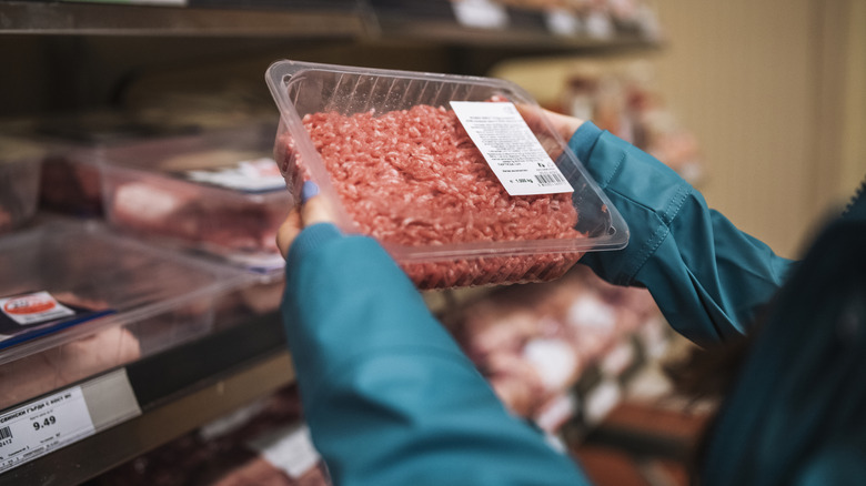 shopper looking at a meat label in the grocery store