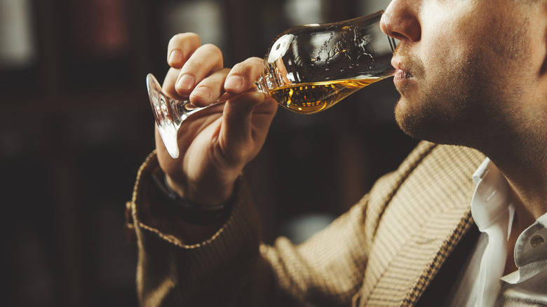 Person sipping whiskey