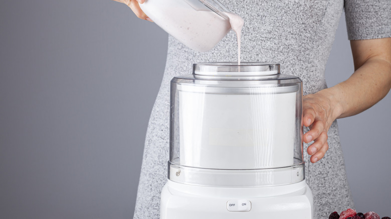 A home cook pouring milk into an ice cream maker