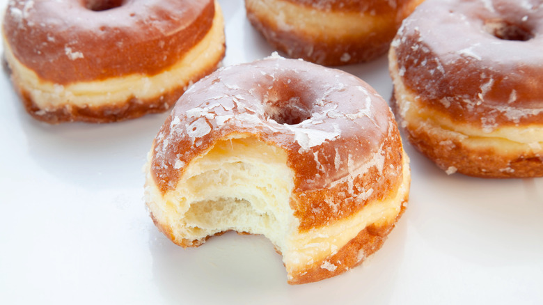 Glazed brioche donuts including one with a bite taken out