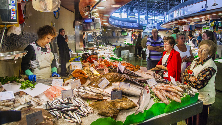 A scene from a seafood busy market with interested shoppers looking at their options