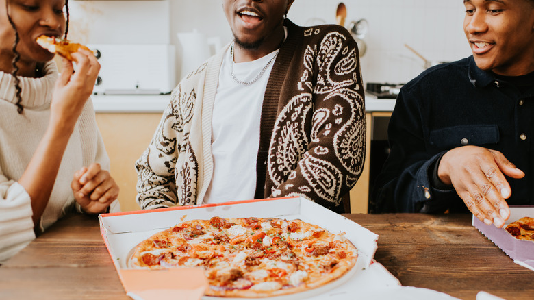friends eating pizza in pizzeria