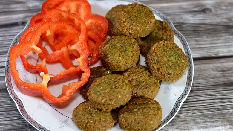 Ta'ameya di piring dengan paprika merah