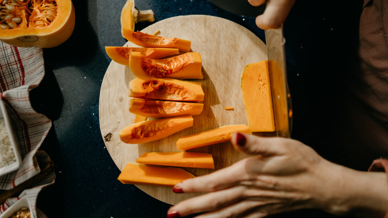 A woman slicing food on a round cutting board