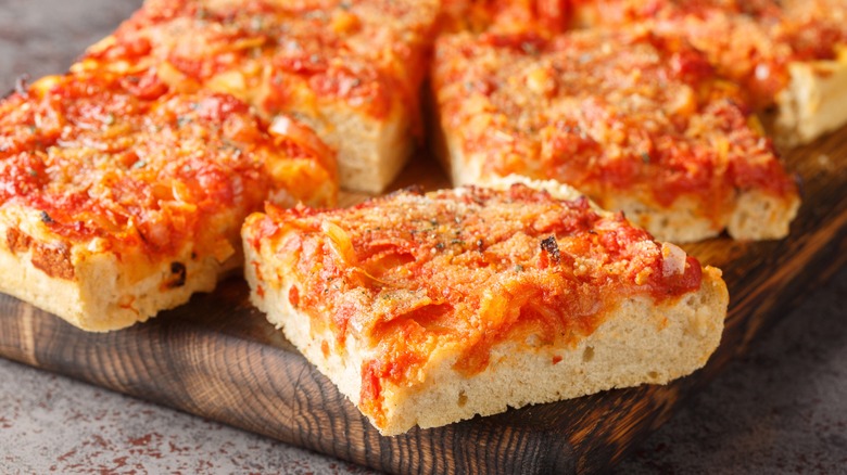 Sicilian pizza on wooden cutting board