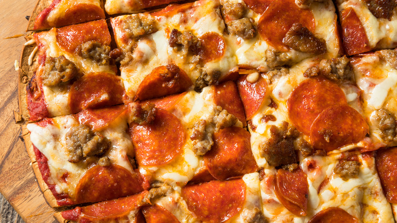 close-up of St. Louis-style pizza with sausage and pepperoni cut into squares