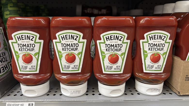 Bottles of Heinz ketchup lined up next to each other.