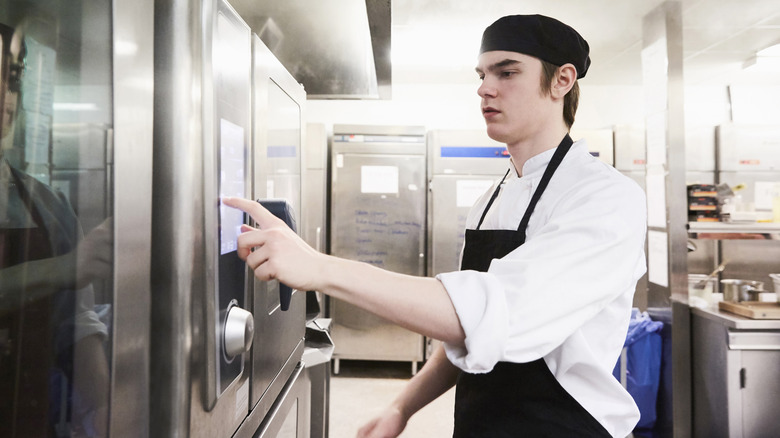 restaurant worker using a touchscreen microwave