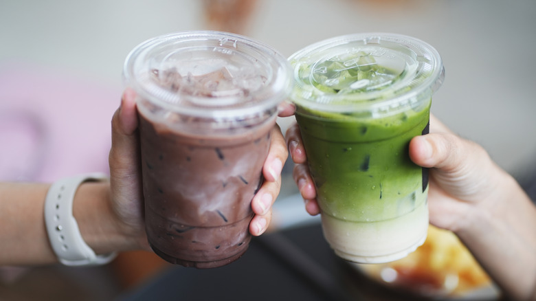 hands holding matcha latte and dirty matcha latte