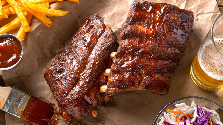 Chicago-style baby back ribs on parchment paper with beer and fries on the side