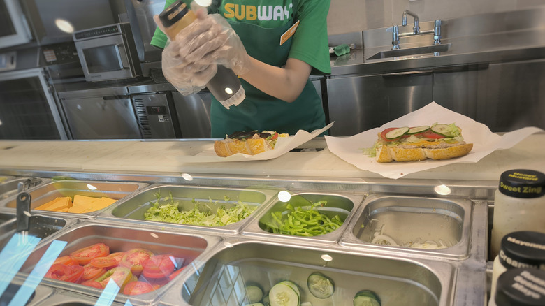 An employee prepares a sandwich at a Subway restaurant