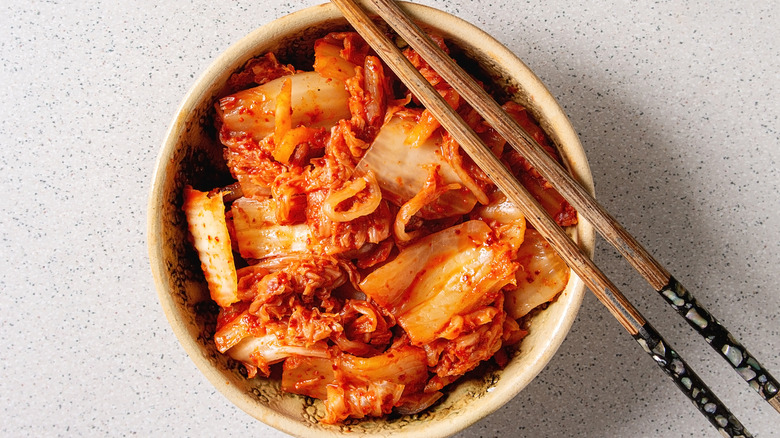 Bowl of kimchi with chopsticks on it