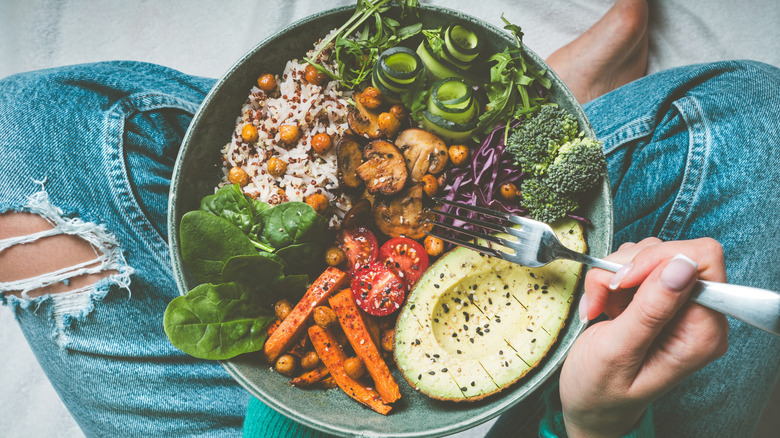 bowl of vegetables in woman's lap