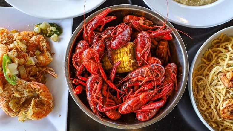 A bowl of boiled crawfish and corn flanked by other dishes at Crawfish Cafe in Cypress