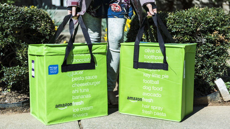 Hands holding two Amazon Fresh bags