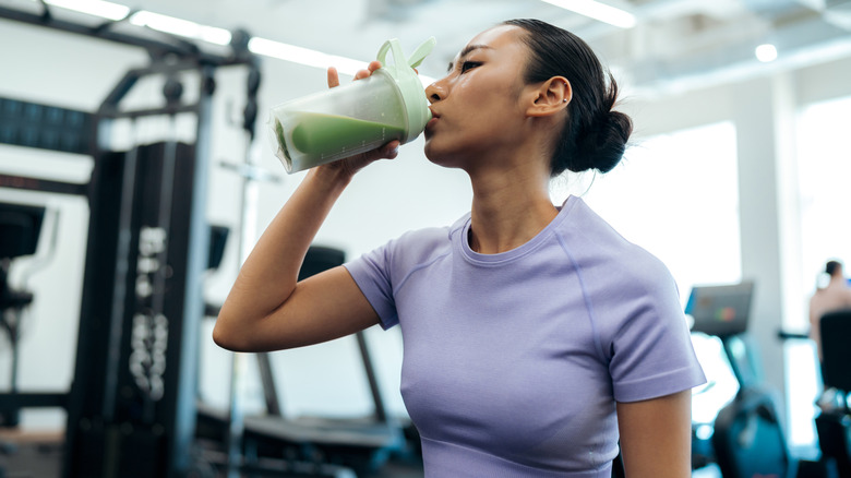Woman drinking protein shake at the gym