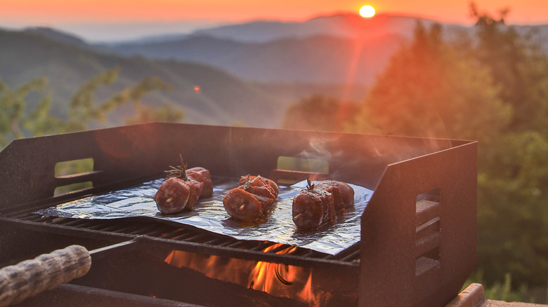 Grilling meat outdoors near mountains