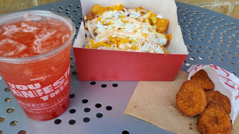 Chicken Shnuggetz, a loaded Totz platter, and a Strawberry Refresher from Sheetz on gray table