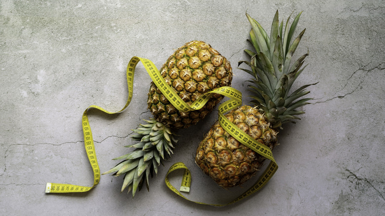 Pineapples wrapped with tape measure, dieting concept