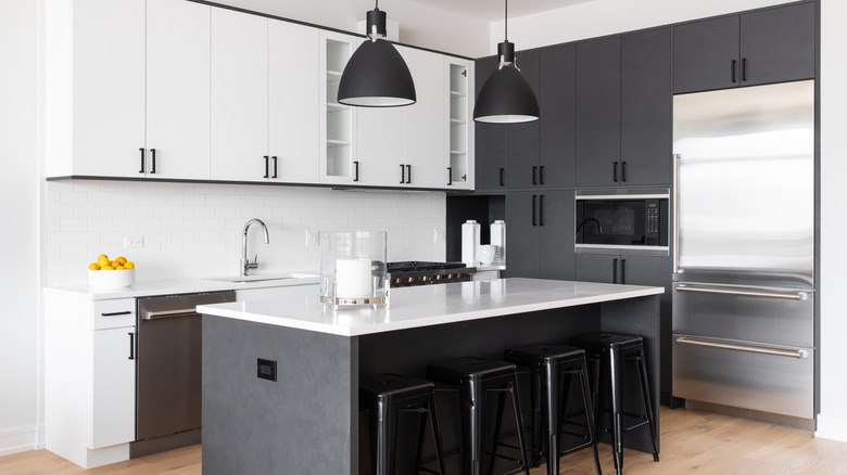 A simple, neutral-toned kitchen with a kitchen island, complete with four bar stools.