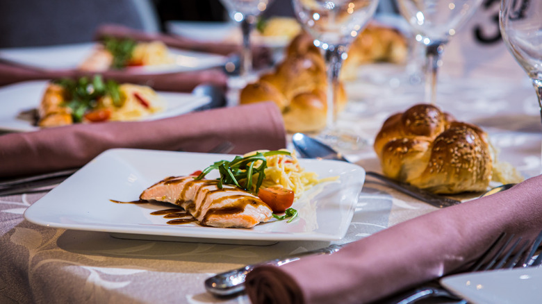 Wedding sit-down dinner with fancy food and tablecloth.